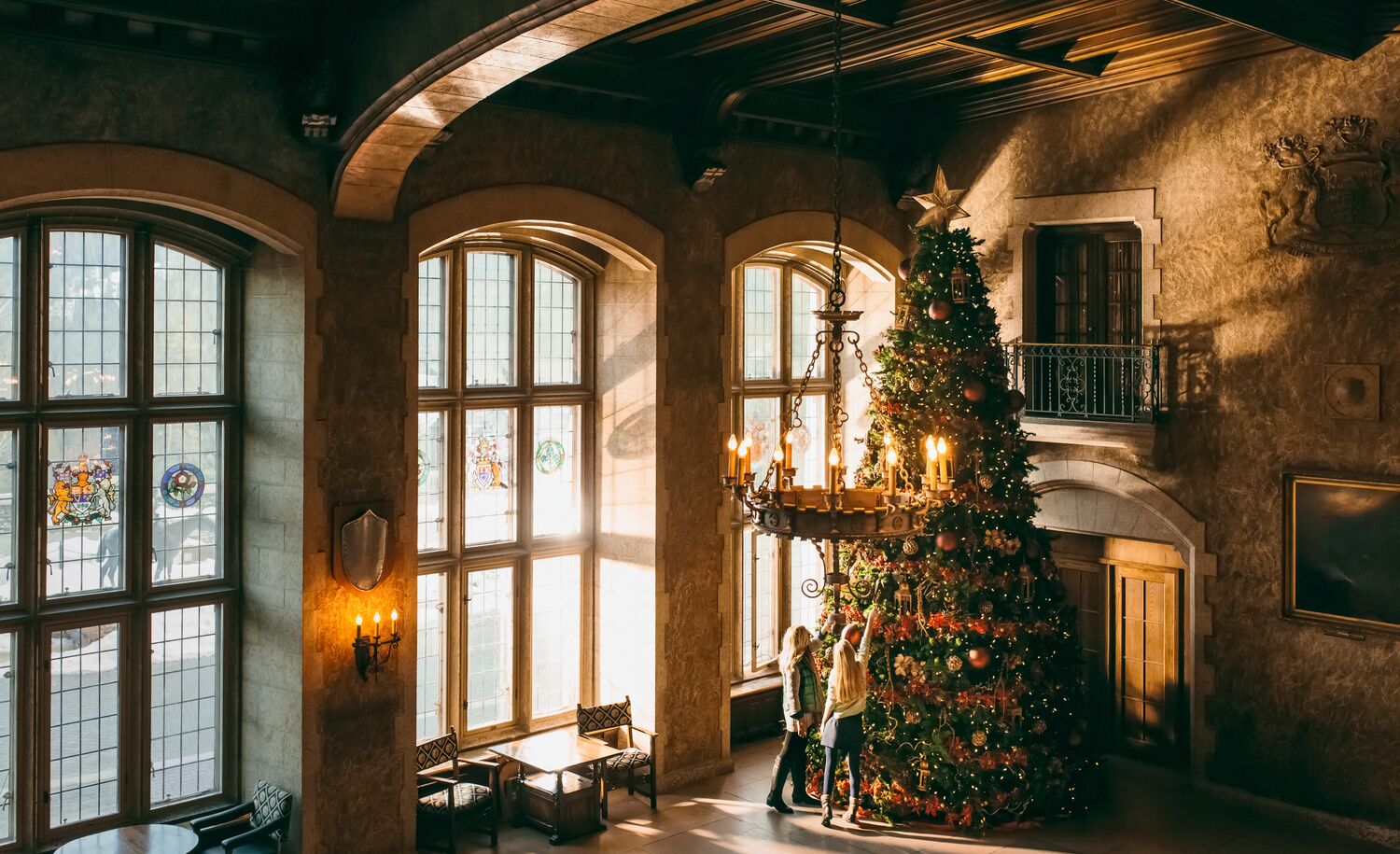 Two people and a giant Christmas tree at the Fairmont Banff Springs hotel in Banff National Park.