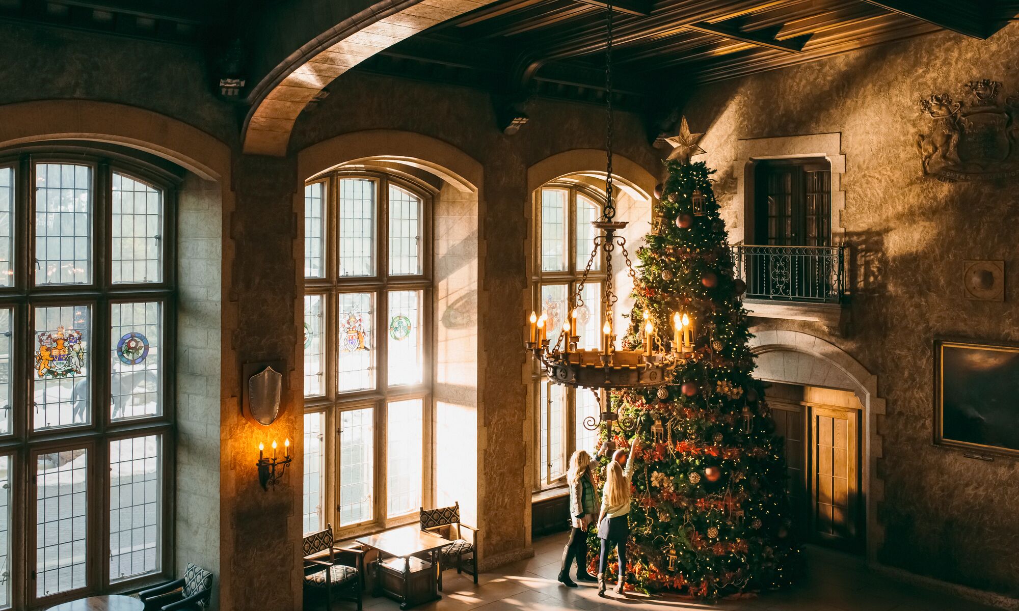 Two people and a giant Christmas tree at the Fairmont Banff Springs hotel in Banff National Park.