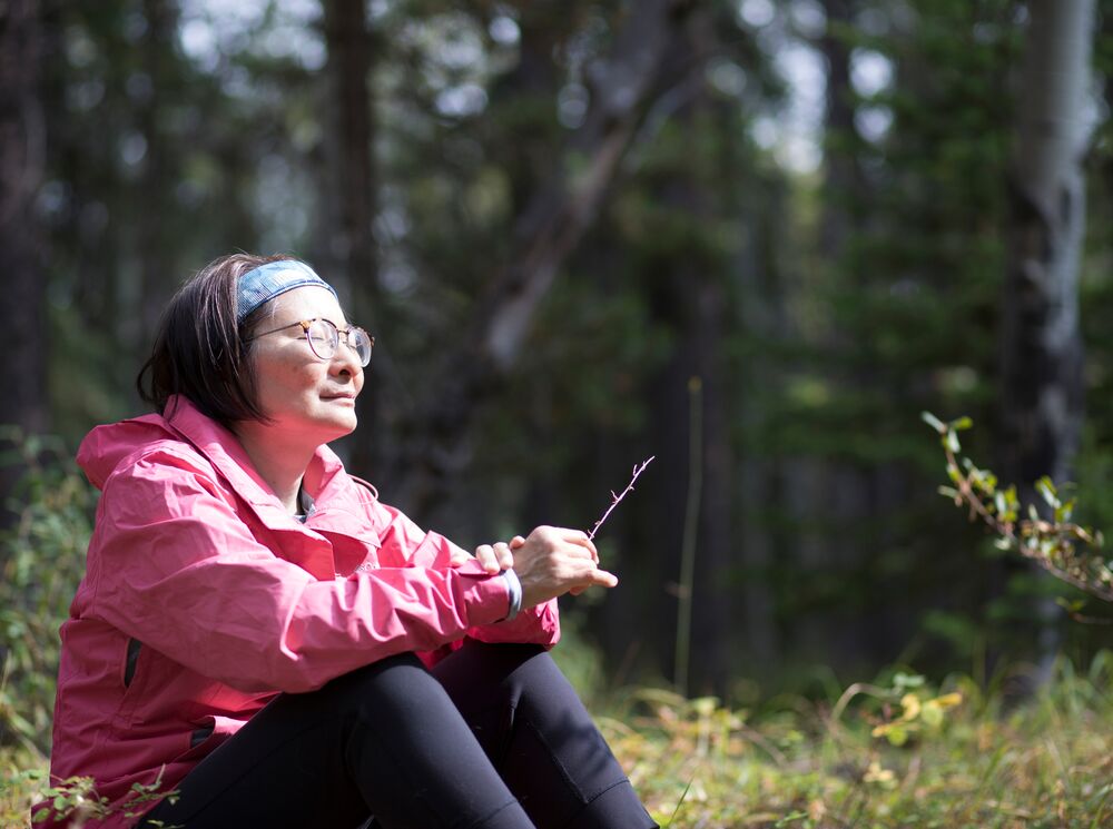 A woman participates in forest bathing with Forest Fix in Banff National Park.