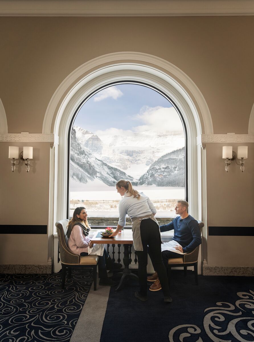 A woman puts ap late on a table at the Chateau Lake Louise