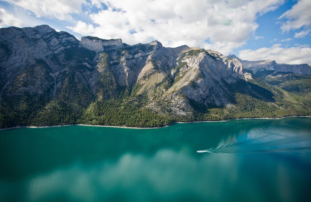 Aerial view of Lake Minnewanka with a boat cruising the waters