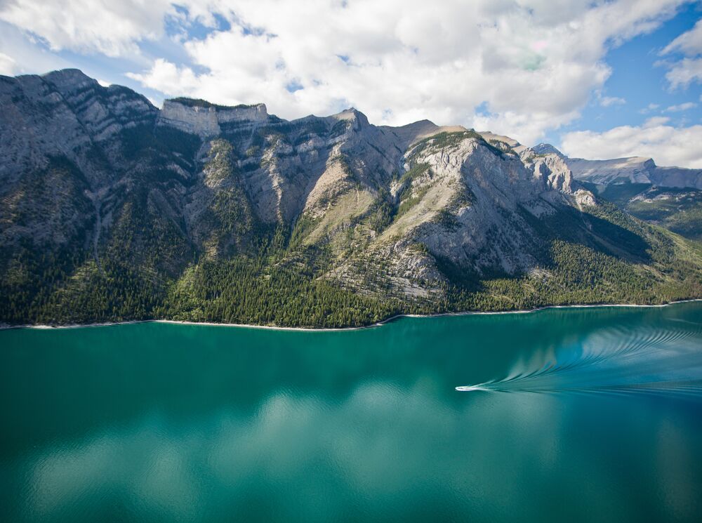 Aerial view of Lake Minnewanka with a boat cruising the waters
