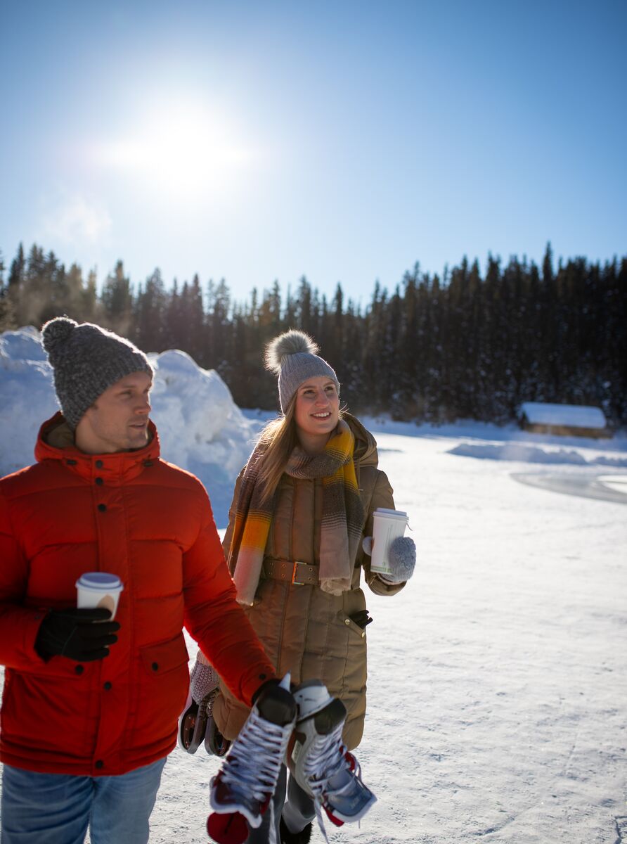 A couple walks towards the rink at Lake Louise in Banff National Park.