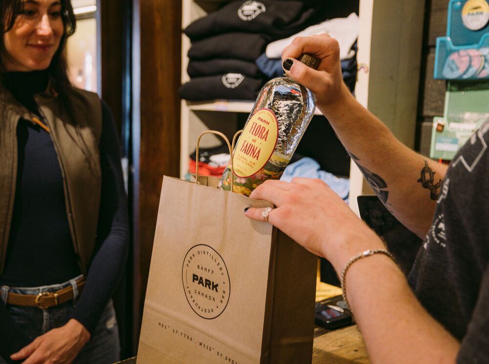 A woman buys a bottle of gin at the PARK Distillery retail store. 