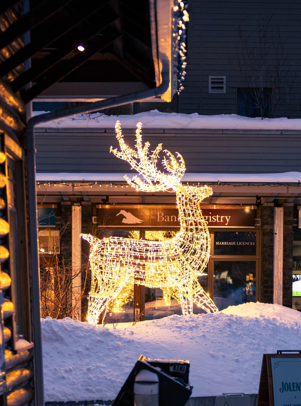 A light up elk sits in a snowbank around shops in Banff.