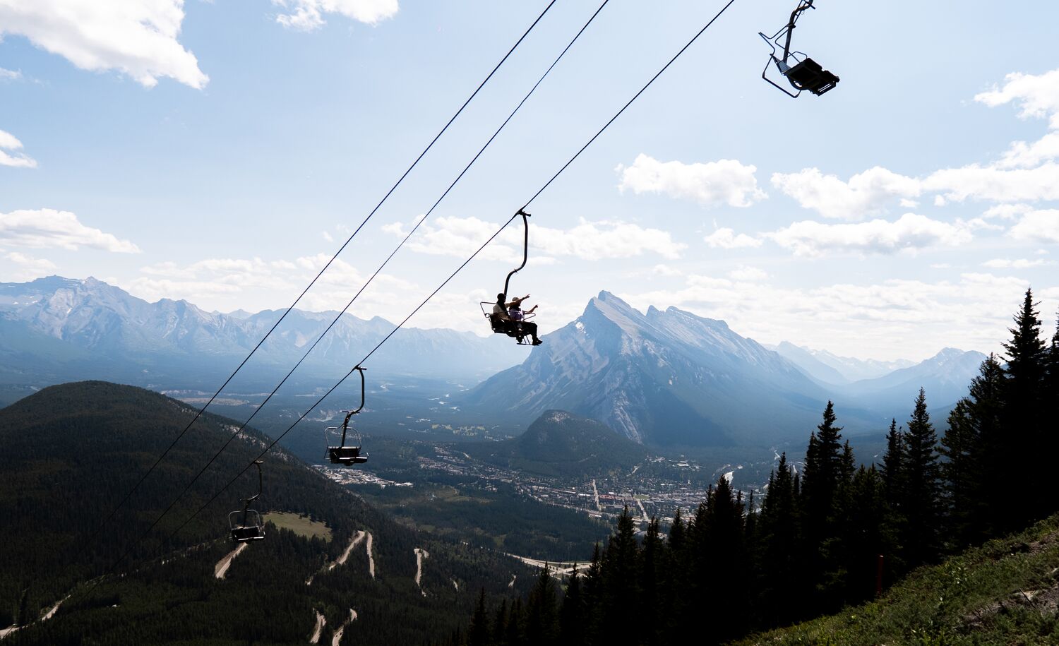 Two people in the Mount Norquay Sightseeing Chairlift, a popular thing to do in Banff in July