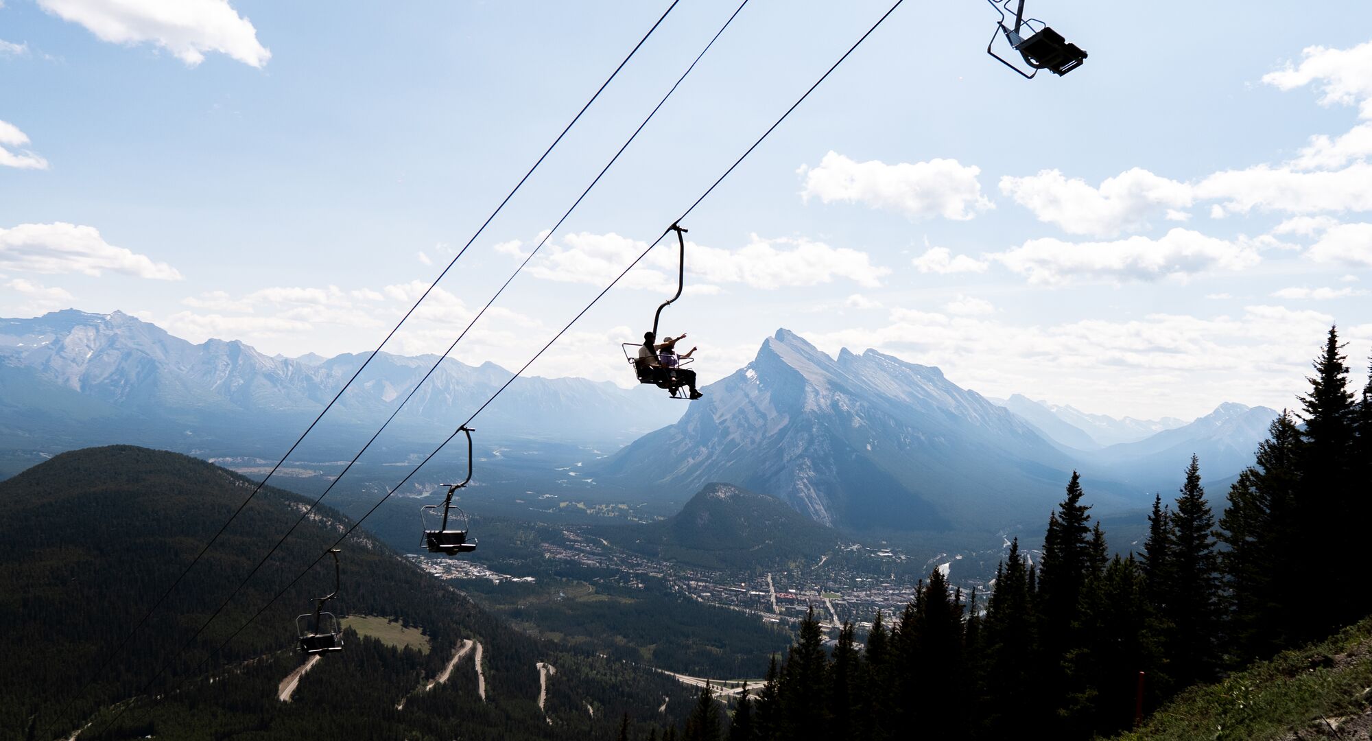 People on a chairlift over looking the town of Banff