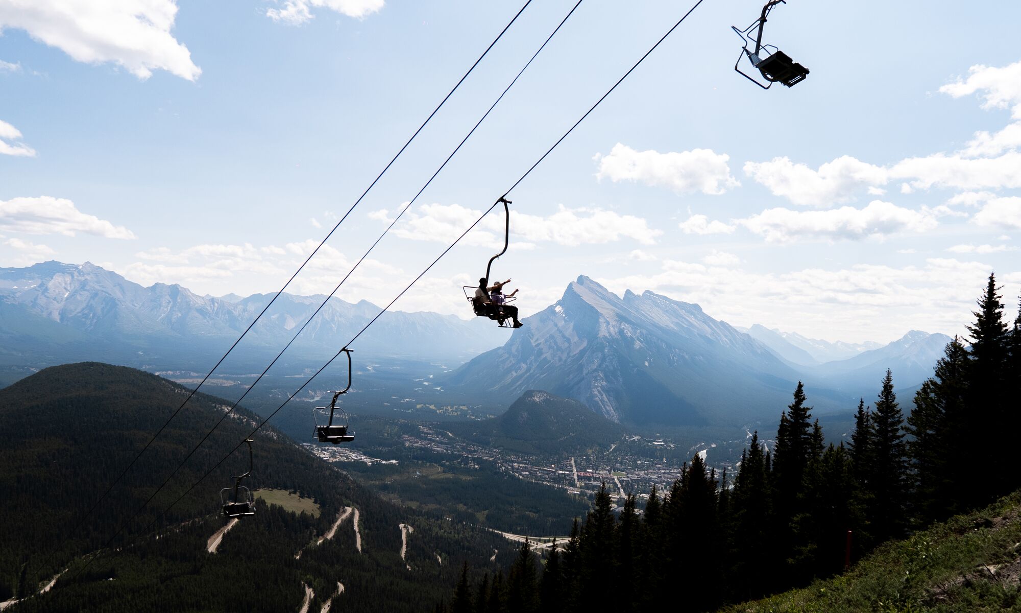 Two people in the Mount Norquay Sightseeing Chairlift, a popular thing to do in Banff in July