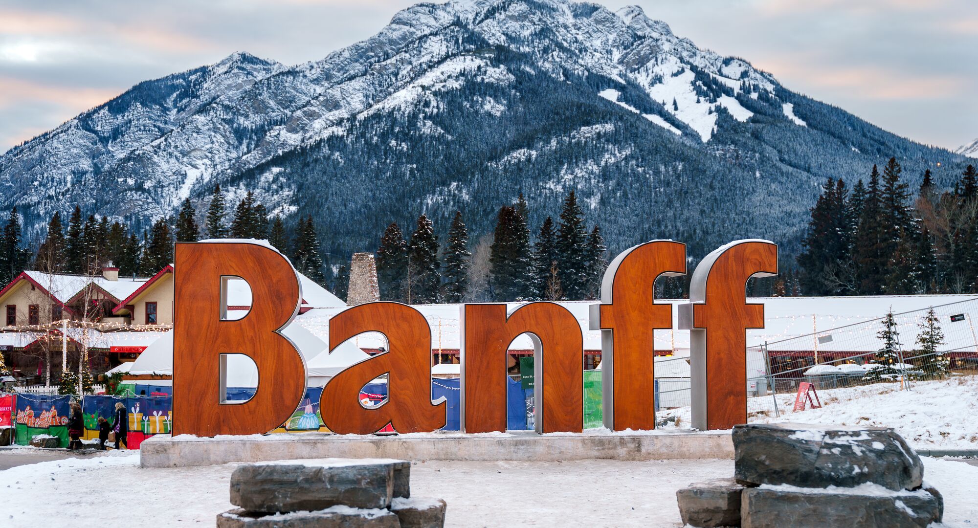 The iconic Banff sign with Cascade Mountain in the background and snow on the ground