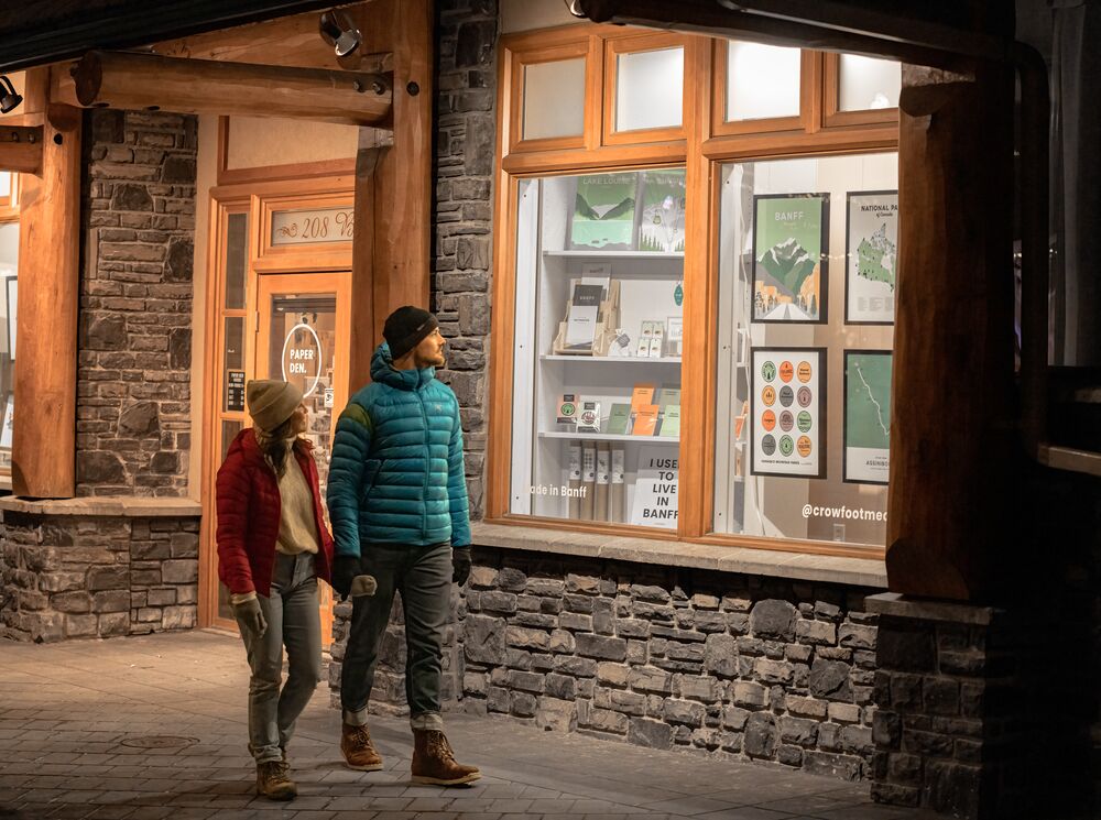 A couple walks on Bear Street in Banff.