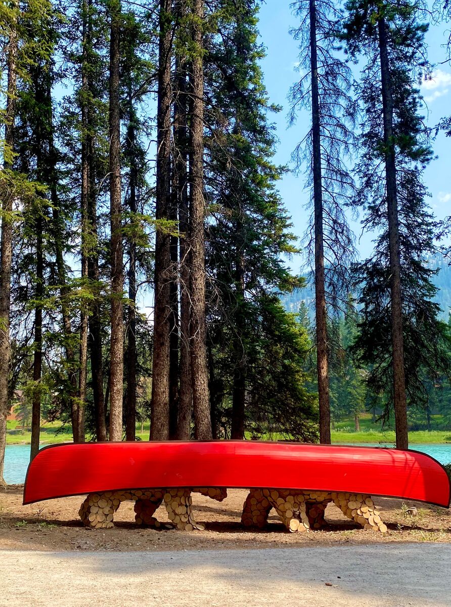 A statue of two bears carrying a red canoe on their back during the Art in Nature Trail in Banff.