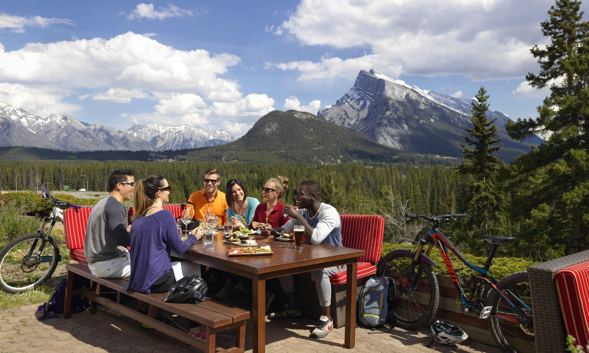 A group of people on an outdoor patio in Banff National Park, a popular thing to do in August