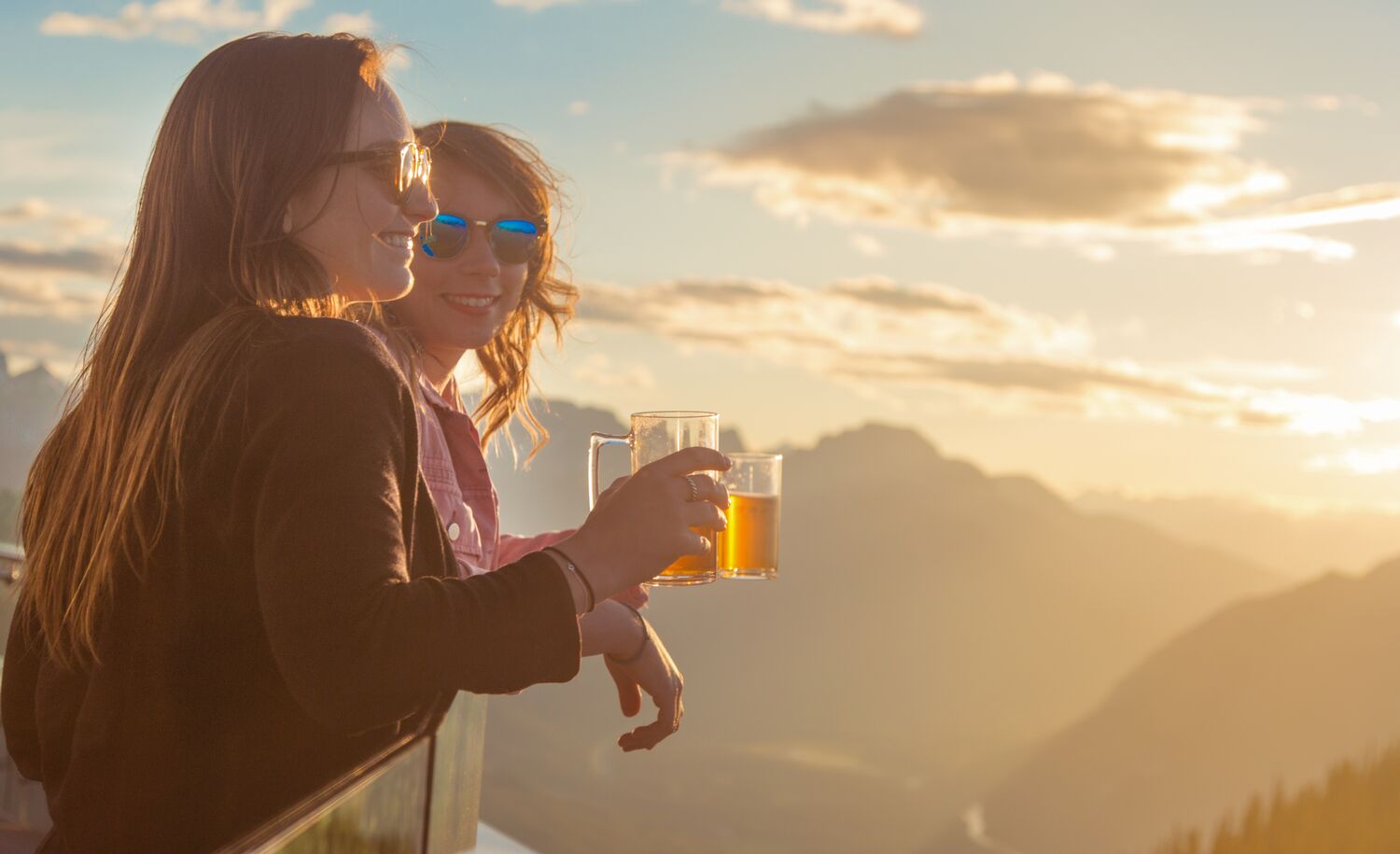Two people having a dring on top of the Banff Gondola at the Sunset festival, a popular event in Banff in August