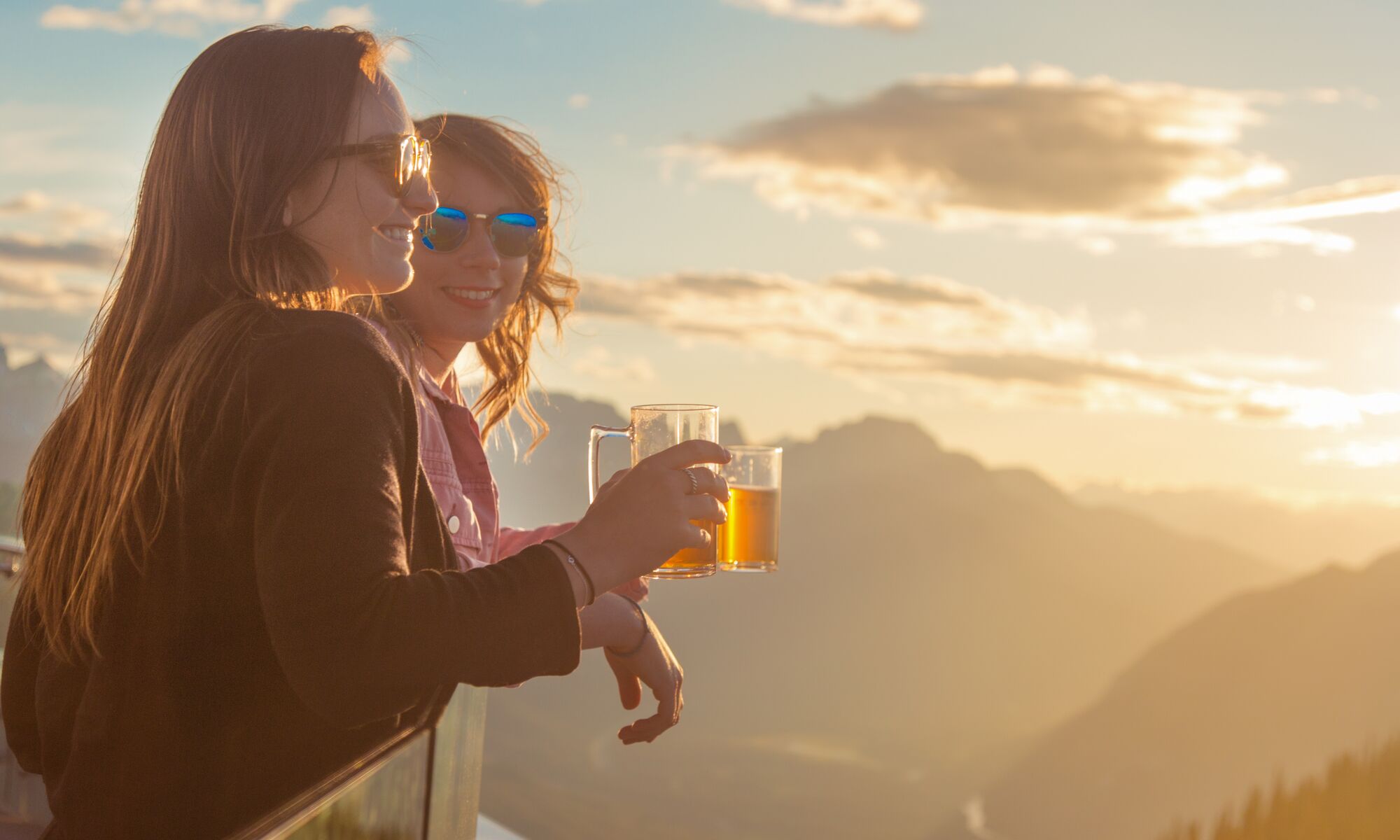 Two people having a dring on top of the Banff Gondola at the Sunset festival, a popular event in Banff in August