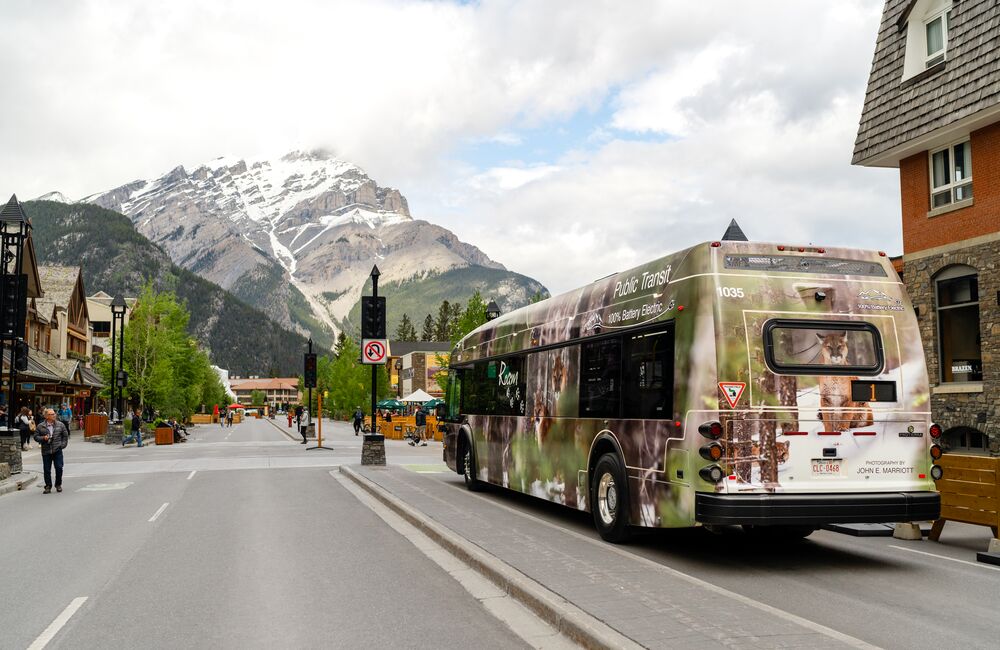 A Roam Transit public transportation bus travels down Banff Avenue