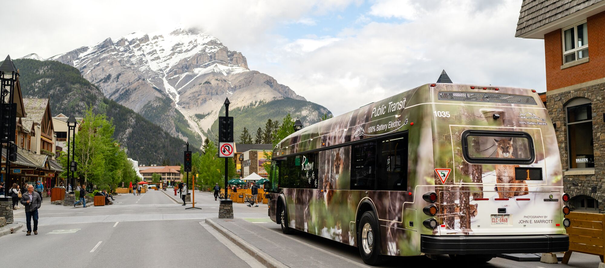 A Roam Transit public transportation bus travels down Banff Avenue