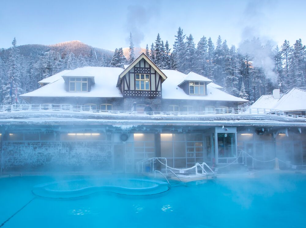 The exterior of the main bathhouse building at the Banff Upper Hot Springs covered in snow on a chilly winter day.