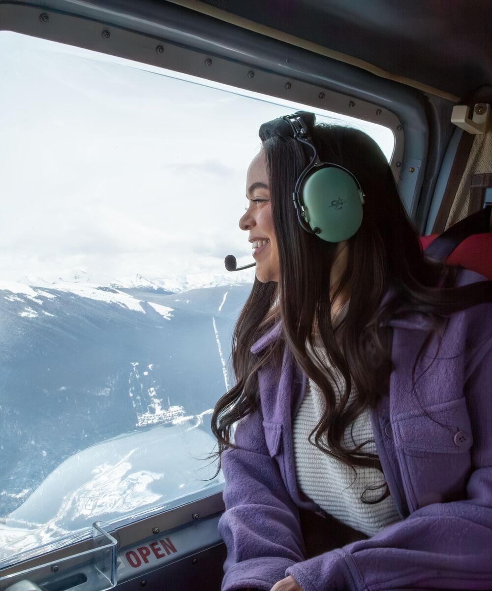 A person on a heli ride in the winter over the Canadian Rockies.