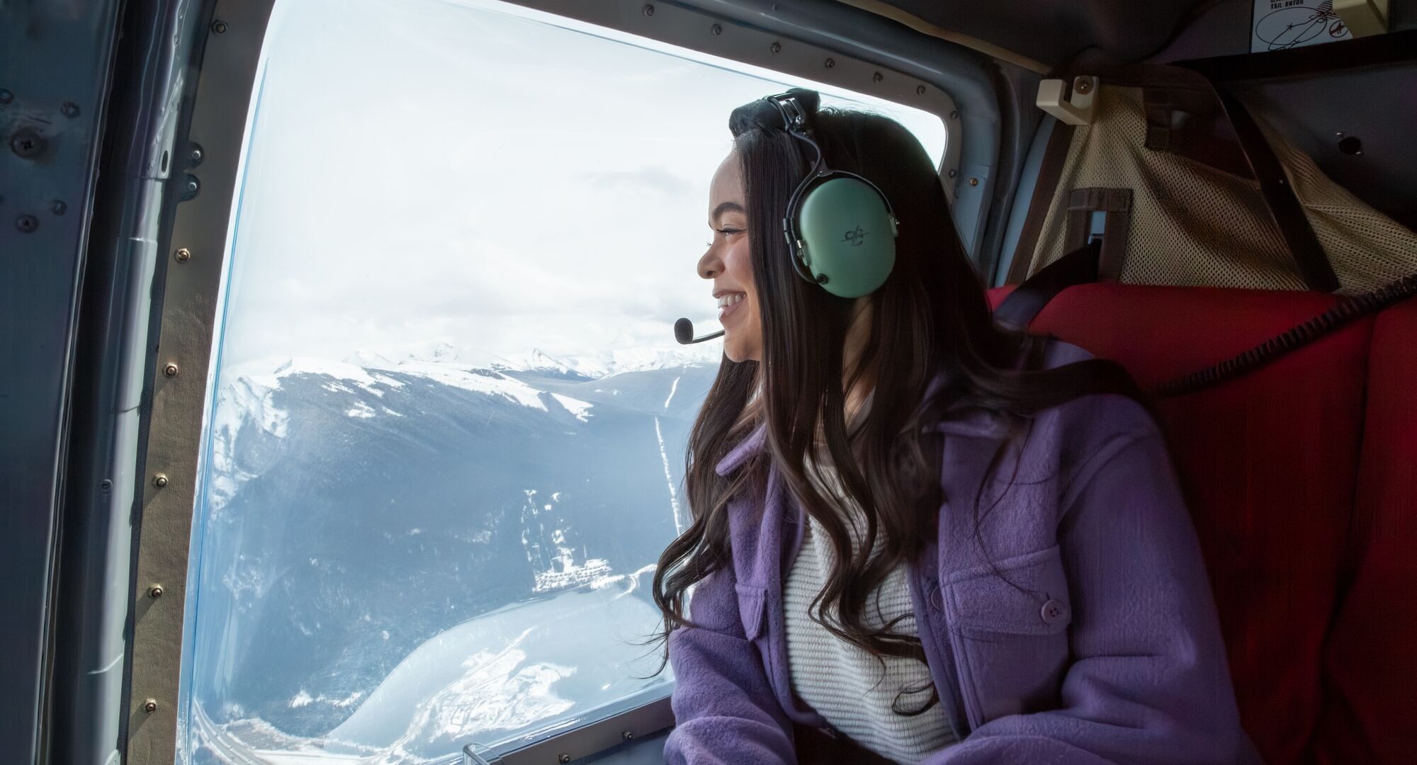 A person on a heli ride in the winter over the Canadian Rockies.