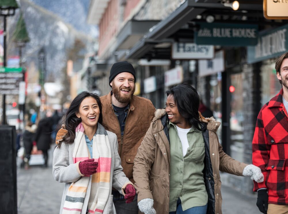 A group of friends happily walking along Banff Avenue to go shopping 