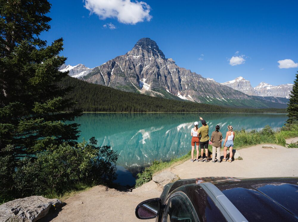 A group stands on the edge of Waterfowl Lakes in Banff National Park.